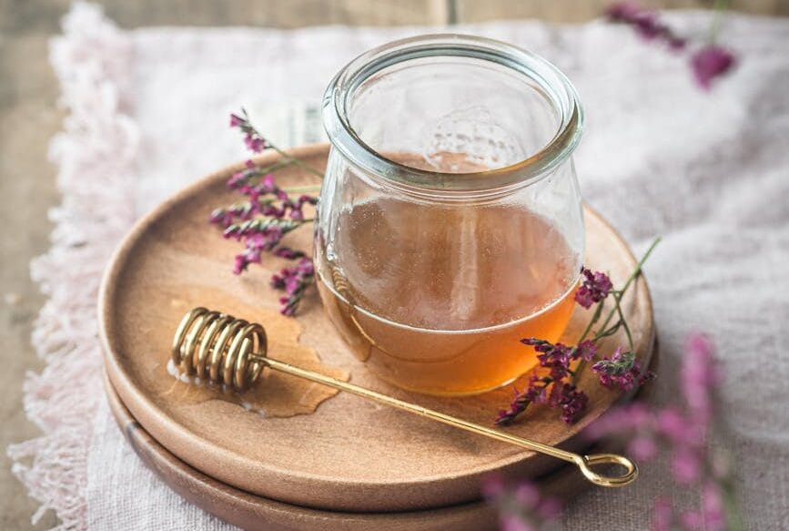 still life with a jar of honey and herbs